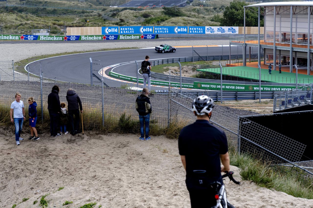 Passanten slaan maandag de opbouw voor de Formule 1-race op circuit Zandvoort gade.