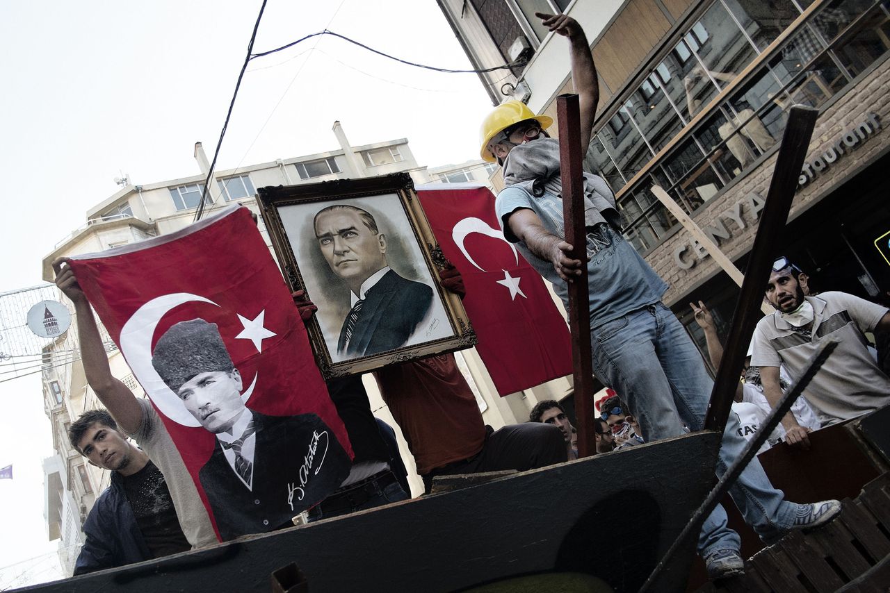Demonstranten in de buurt van het Taksimplein houden Turkse vlaggen omhoog en een portret van de oprichter van het moderne Turkije, Mustafa Kamal Ataturk.