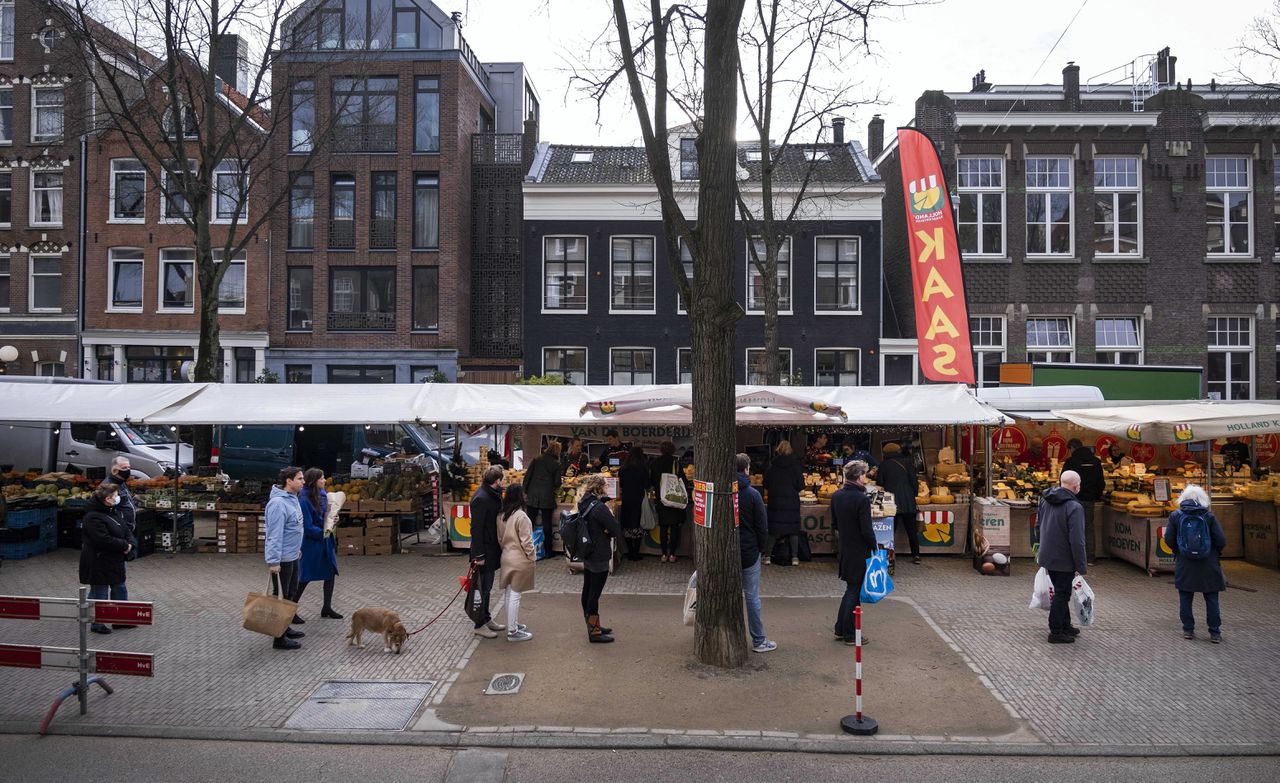 Mensen staan in de rij op de markt bij de Lindengracht. Veel winkels zijn gesloten tijdens de harde lockdown, bezoekers zoeken hun vertier daarom op markten.