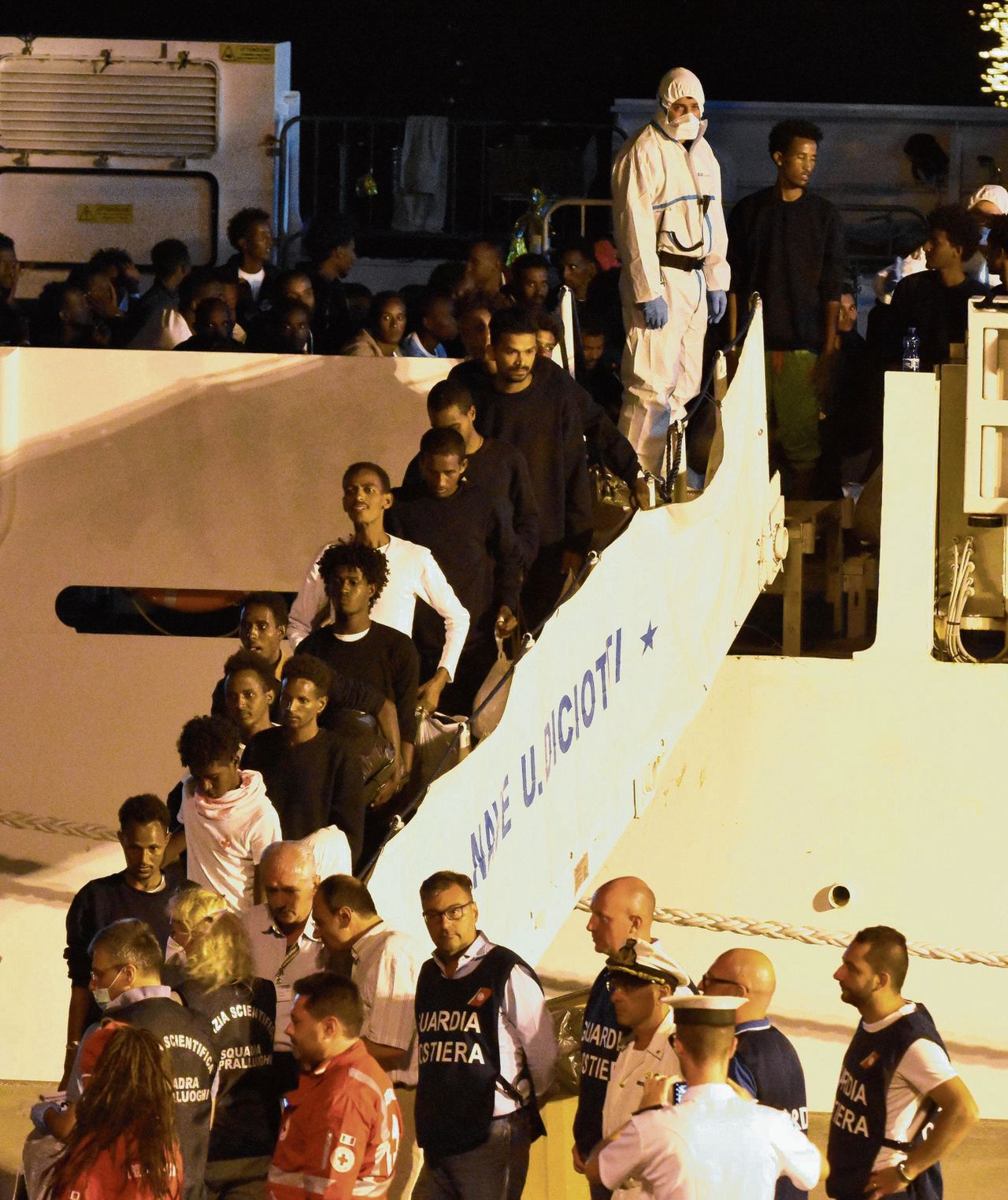 Migranten opkustwachtschip Diciotti dat bij de Siciliaanse stad Catania ligt mogen van boord. De Italiaanse katholieke kerk zal het grootste deel van hen opnemen, ook Ierland en Albanië nemen opvarenden op.