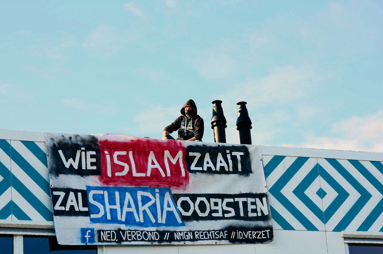 Op het dak van de nieuwe middelbare islamitische school in de Amsterdamse wijk Nieuw-West staan twee mannen met bivakmutsen over hun hoofd. Ze hebben een spandoek aan de gevel gehangen met de tekst: 'Wie islam zaait, zal sharia oogsten'.