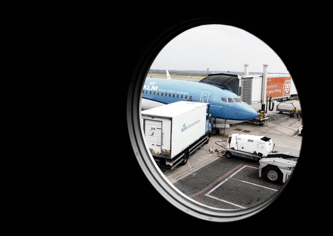 Een vliegtuig van KLM op Schiphol Airport. En een cabinemedewerker (linksonder). Omdat het iets beter gaat in de luchtvaart, hoeven minder cabinemedewerkers te vertrekken. Foto’s Koen van Weel/ANP