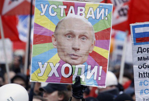 A protester holds a placard during a demonstration against recent parliamentary election results in Moscow December 24, 2011. Tens of thousands of flag-waving and chanting protesters called on Saturday for a disputed parliamentary election to be rerun, increasing pressure on Vladimir Putin as he seeks a new term as Russian president. The placard reads "Get tired! Leave!" REUTERS/Sergei Karpukhin (RUSSIA - Tags: POLITICS CIVIL UNREST)