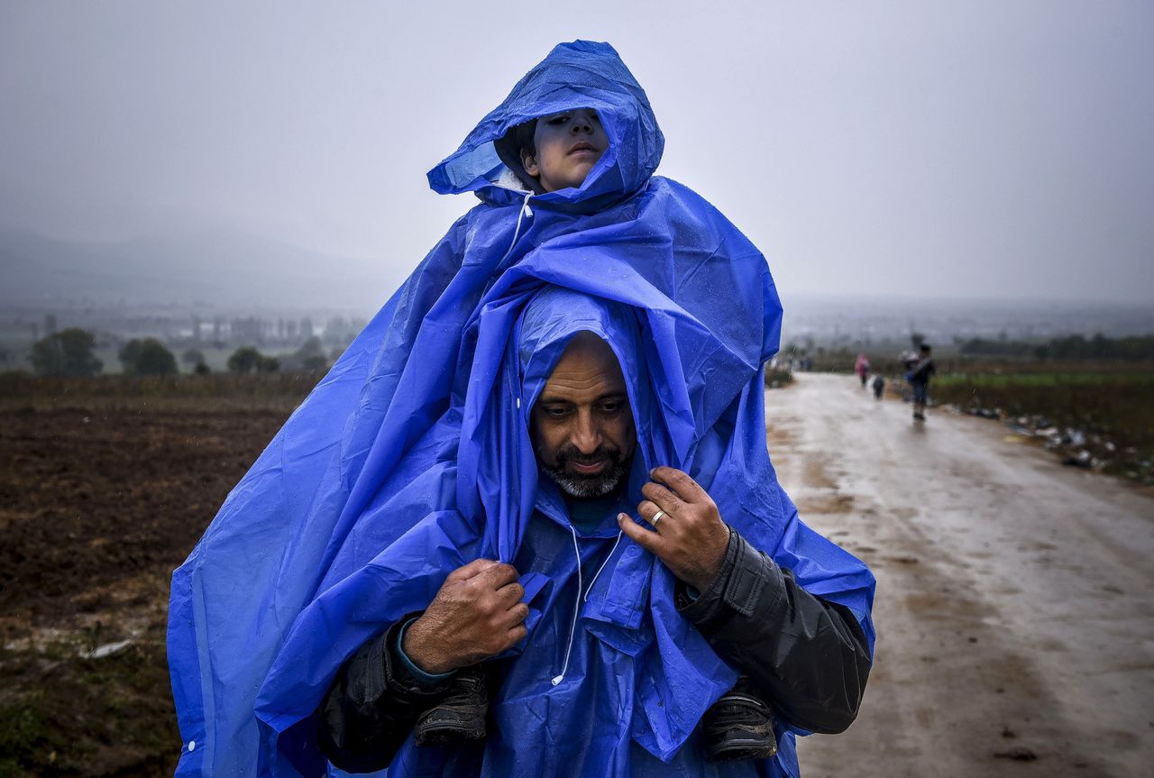 Vader en zoon steken de grens tussen Macedonië en Servië over.