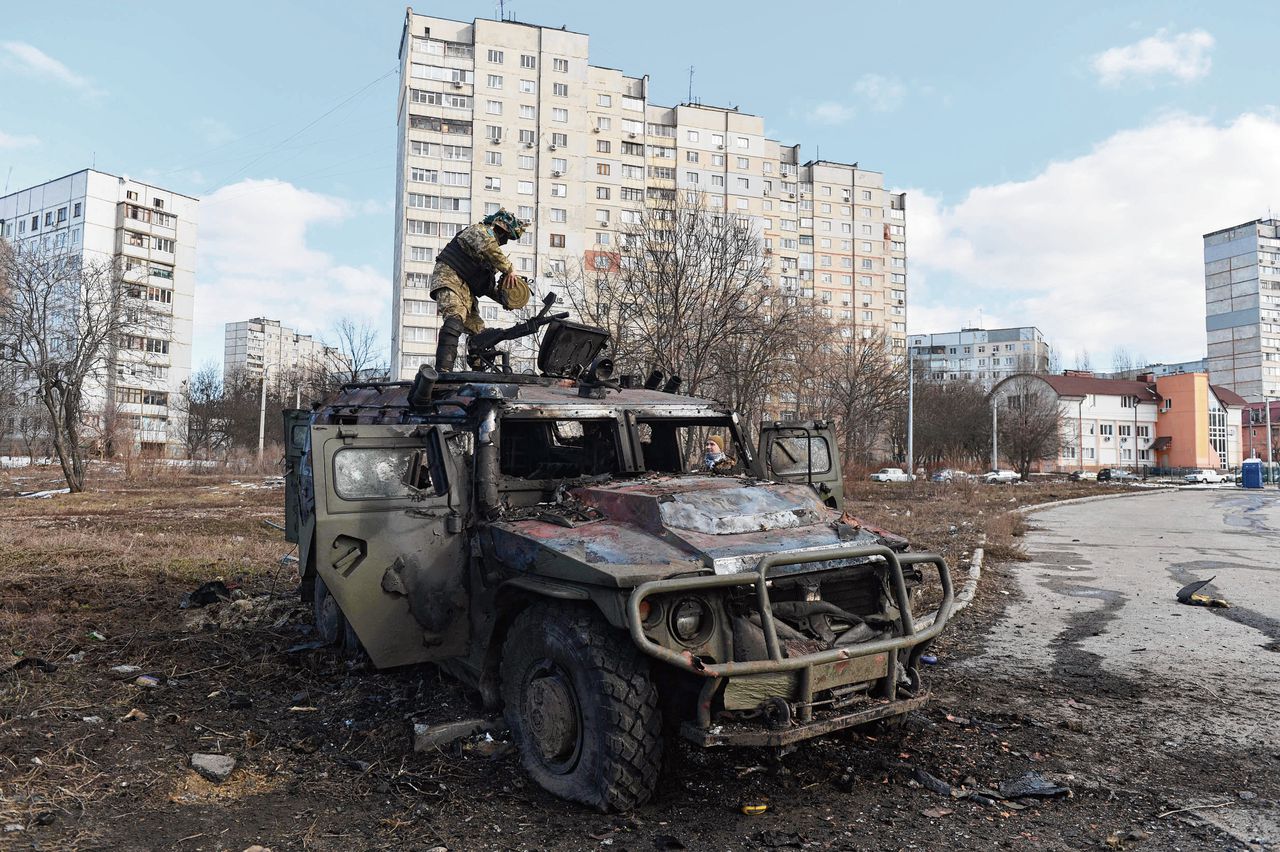 Een Oekraïense soldaat bekijkt een vernield voertuig van het Russische leger, zondag in Charkov.