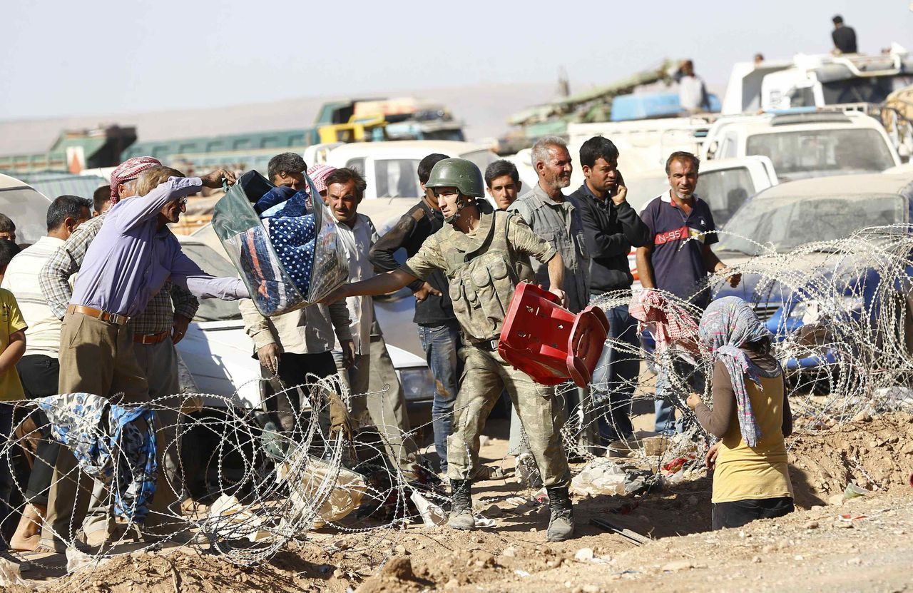 Syrische vluchtelingen steken de Turkse grens over. De gevechten om Kobani hebben veel Syrische Koerden op de vlucht gejaagd.