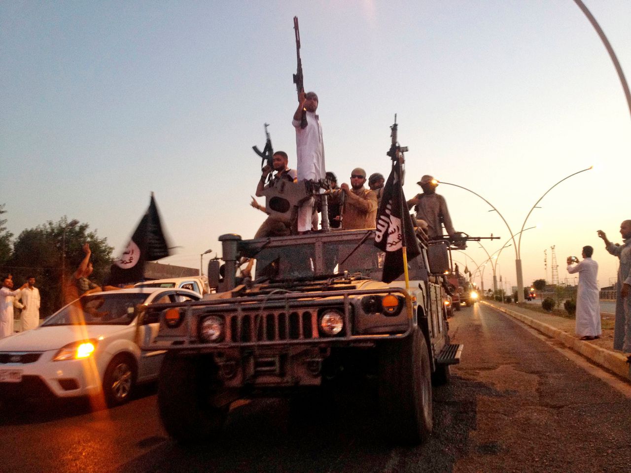 IS-strijders rijden door de Iraakse stad Mosul in 2014, waarvandaan Baghdadi datzelfde jaar ook het kalifaat uitriep.