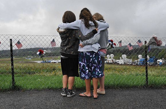 Drie meisjes kijken op de dag voor de ceremonie naar het veld in Shanksville, Pennsylvania, waar vlucht 93 van United Airlines op 11 september 2001 neerstortte. Foto AFP / Nicholas Kamm