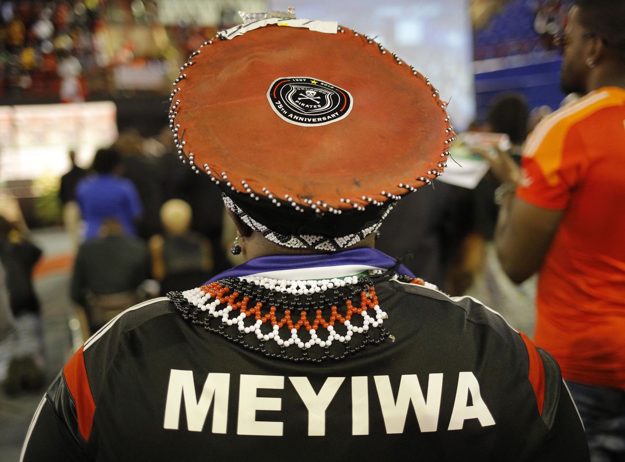 Een voetbalsupporter draagt het shirt van de vermoorde keeper Senzo Meyiwa tijdens een herdenkingsdienst.