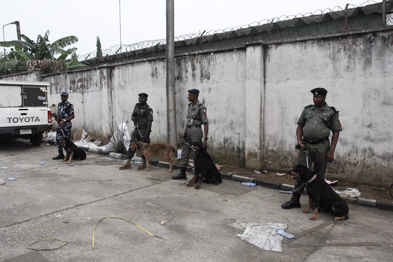 Nigeriaanse agenten met honden beveiligen een stemlokaal in de stad Port Harcourt in de Nigerdelta.