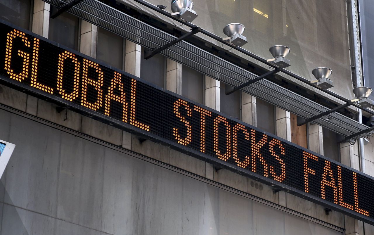 Het nieuws van de wereldwijde koersval verschijnt op de informatieborden op Wall Street.
