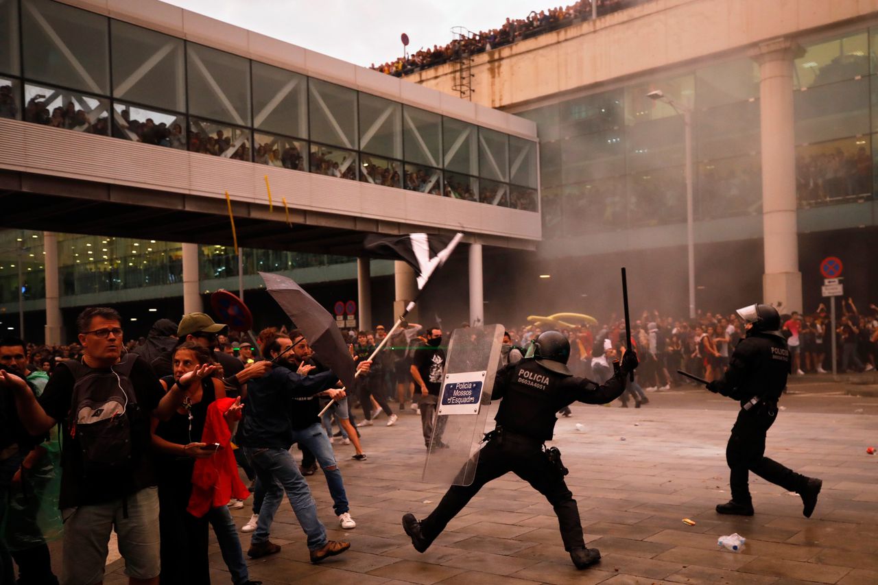 Demonstranten raken maandag slaags met de politie bij het vliegveld in Barcelona.