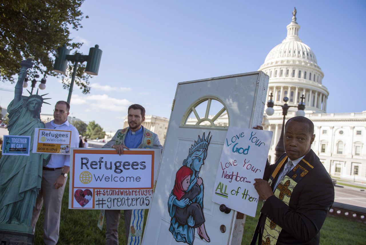 Mensen roepen tijdens een protest in Washington Trump op om meer vluchtelingen binnen te laten.