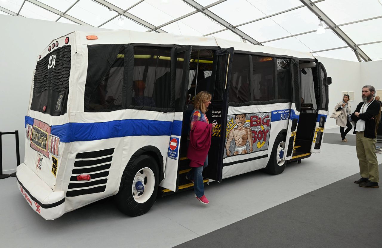 Publiek stapt uit ‘The Bus’ de zachte stadsbus uit New York, een kunstwerk van popartkunstenaar Red Grooms, op de kunstbeurs Frieze in New York.