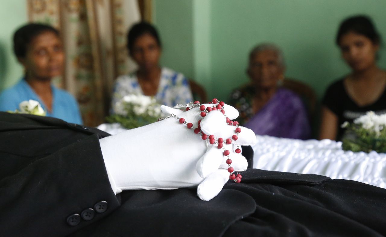 Familieleden bij de uitvaart van een slachtoffer van een van de aanslagen in Colombo. De meeste van de zeker 290 doden die bij het geweld vielen, zijn Sri Lankanen.