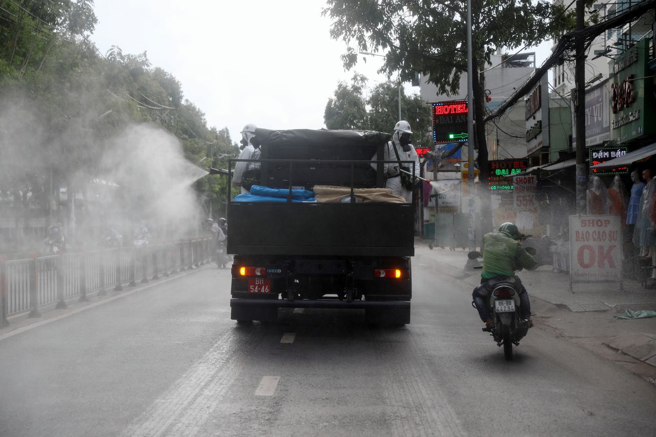 Een vrachtwagen in Vietnam die al rijdend desinfectiespray verspreidt.