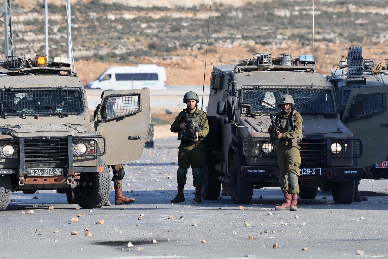 Israëlische militairen blokkeren een weg op de Westelijke Jordaanoever.