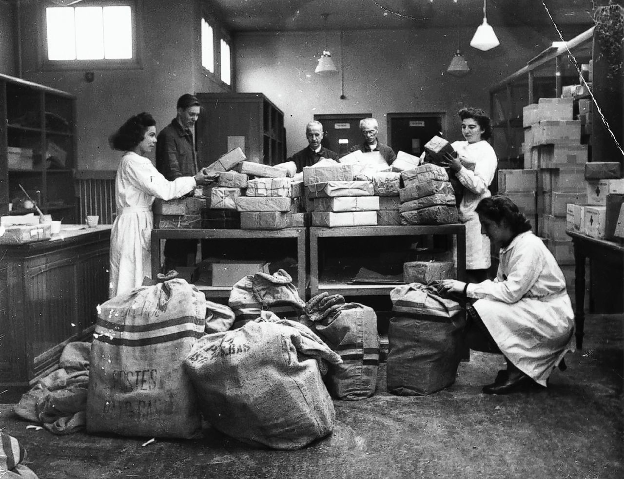 Medewerkers van het Rode Kruis maken pakketten klaar voor Nederlandse krijgsgevangen die in 1942 en 1943 naar Duitse kampen waren gevoerd.