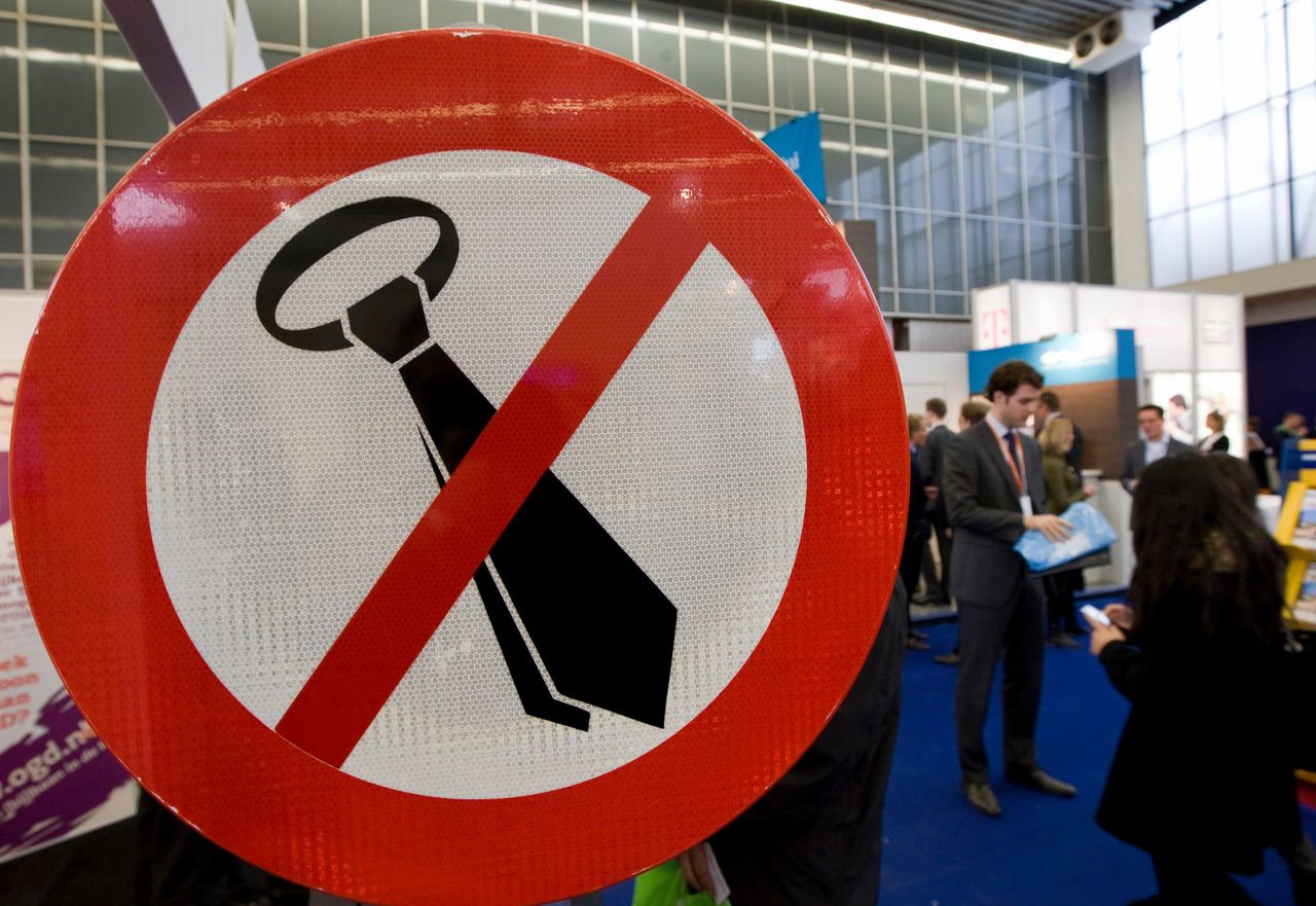 Een verbodsbord voor stropdassen siert een stand van een ICT-bedrijf op de Nationale Carrièrebeurs in de Rai in Amsterdam.