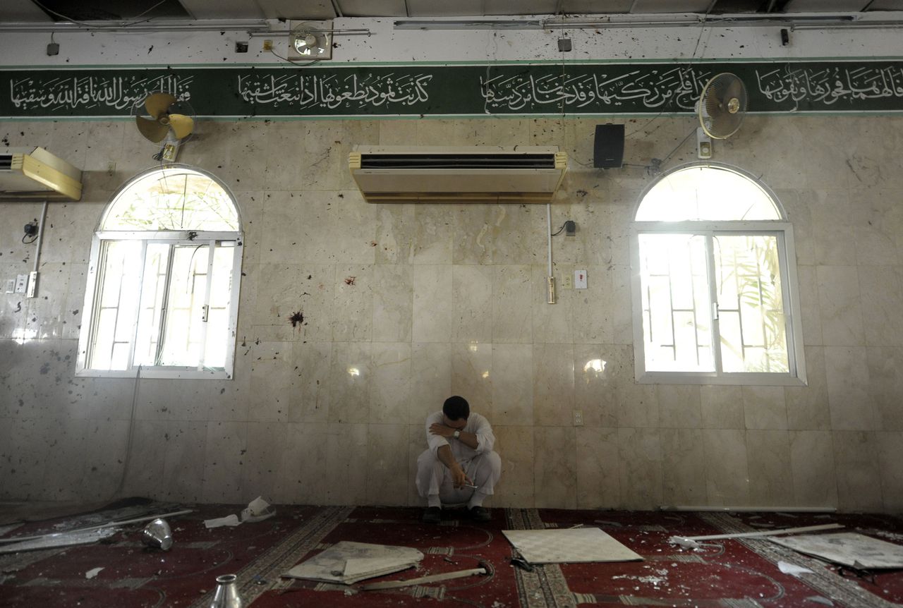 Een Saoedische man zit gehurkt in de moskee, waar even daarvoor een aanslag is gepleegd.