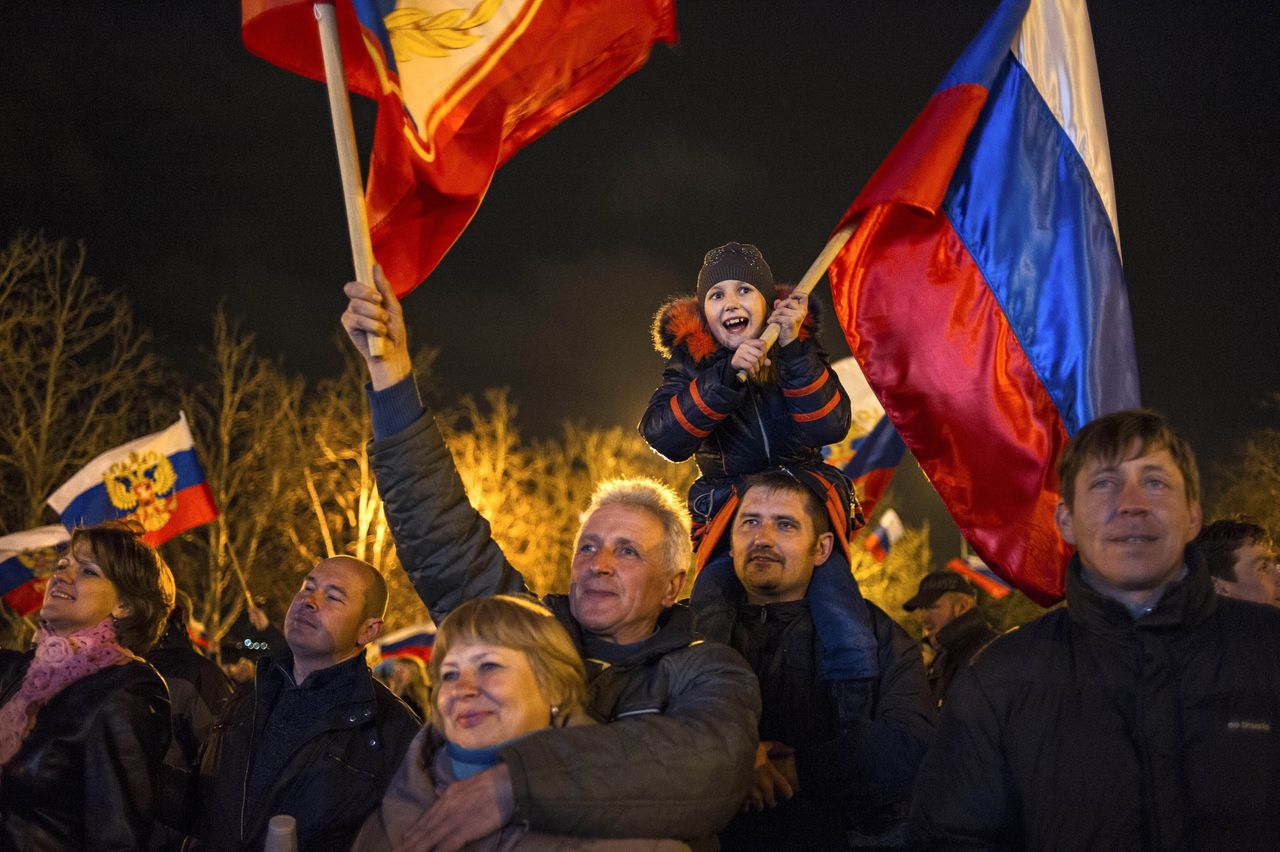 Pro-Russische feestvierders in Sebastopol op de Krim zwaaien met Russische vlaggen na de eerste uitslagen van het referendum.
