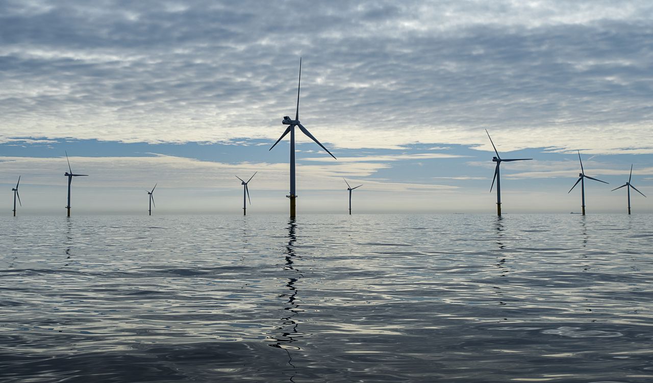 Windmolens reiken boven het wateroppervlakte van de Noordzee, 23 kilometer uit de kust ter hoogte van de strook tussen Zandvoort en Noordwijk.