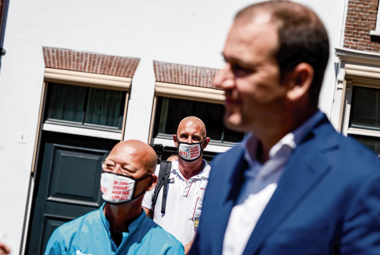 PvdA-leider Lodewijk Asscher staat tussen zorgverleners die bij de Tweede Kamer demonstreren.
