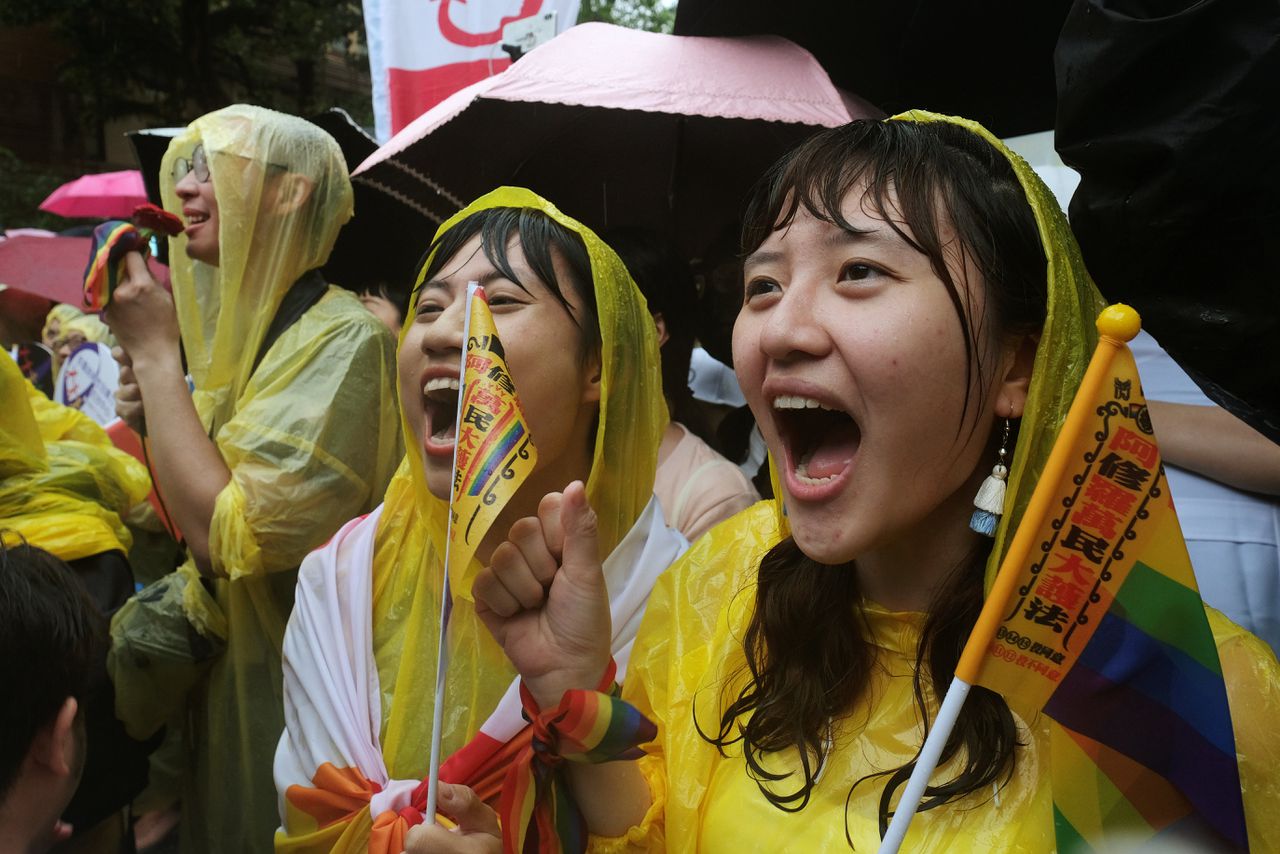 Activisten in de regen bij het parlementsgebouw.