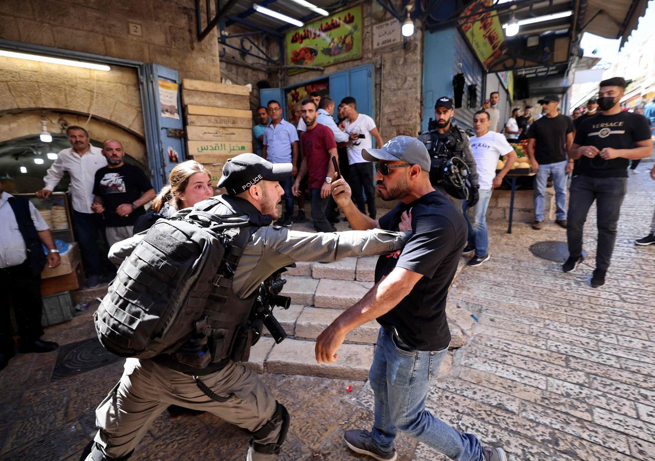 Een Israëlische politieagent in confrontatie met een Palestijnse man tijdens protesten dinsdag op de Westelijke Jordaanoever.