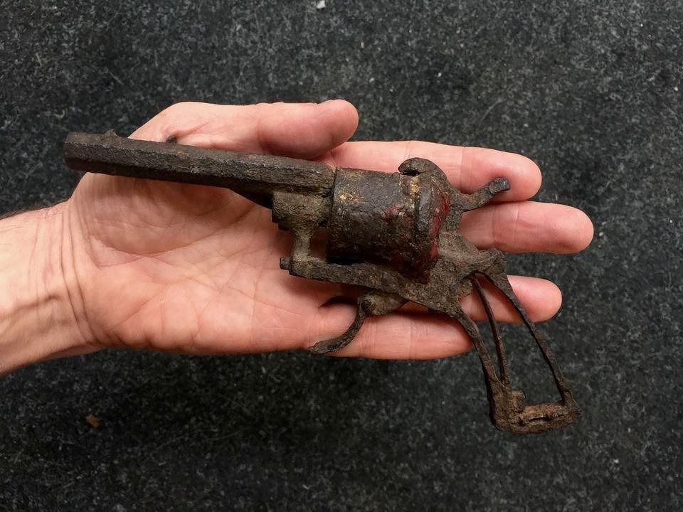 De gecorrodeerde Lefaucheux-revolver waarmee Van Gogh zich mogelijk dodelijk heeft verwond, in de linkerhand van kunstjournalist Martin Bailey, de auteur van ‘Van Gogh’s Finale’.