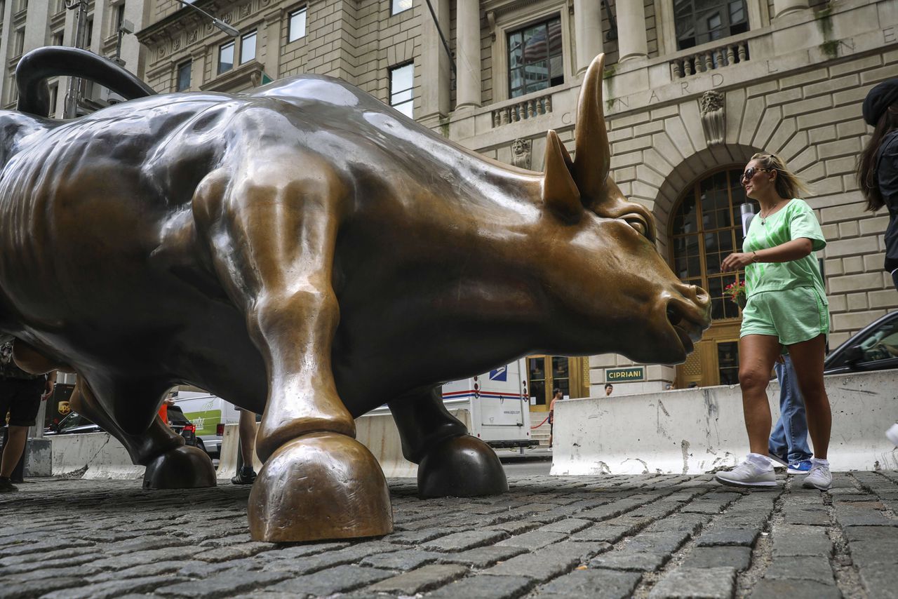 Toerist bij het stierenstandbeeld op Wall Street, New York.