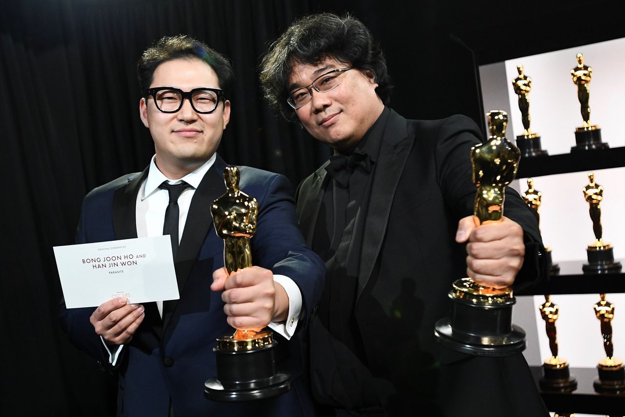 De makers van de film 'Parasite' Bong Joon Ho (r) en Han Jin Won, nemen zondagavond de Oscar voor Beste Film in ontvangst bij het Oscargala in Hollywood.