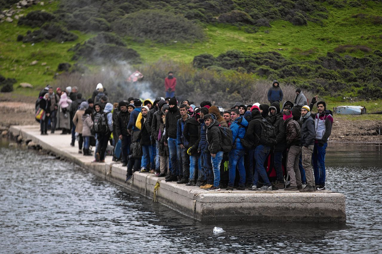 Migranten die zijn afgezet op een verlaten Grieks eiland wachten op de kustwacht.