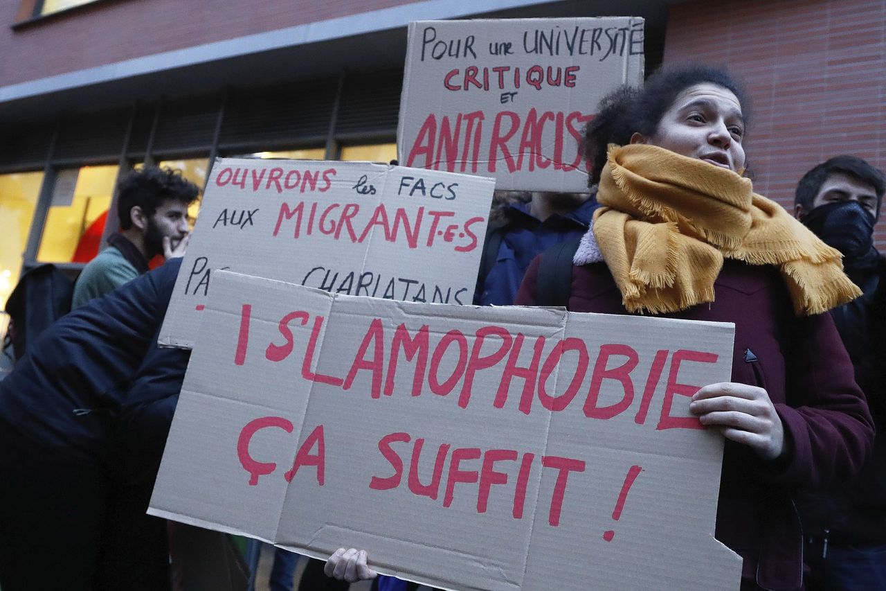 Betogers protesteren tegen het voorlezen van een vermeend islamofoob artikel, geschreven door de Franse cartoonist Charb die bij de aanslag op Charlie Hebdo omkwam.