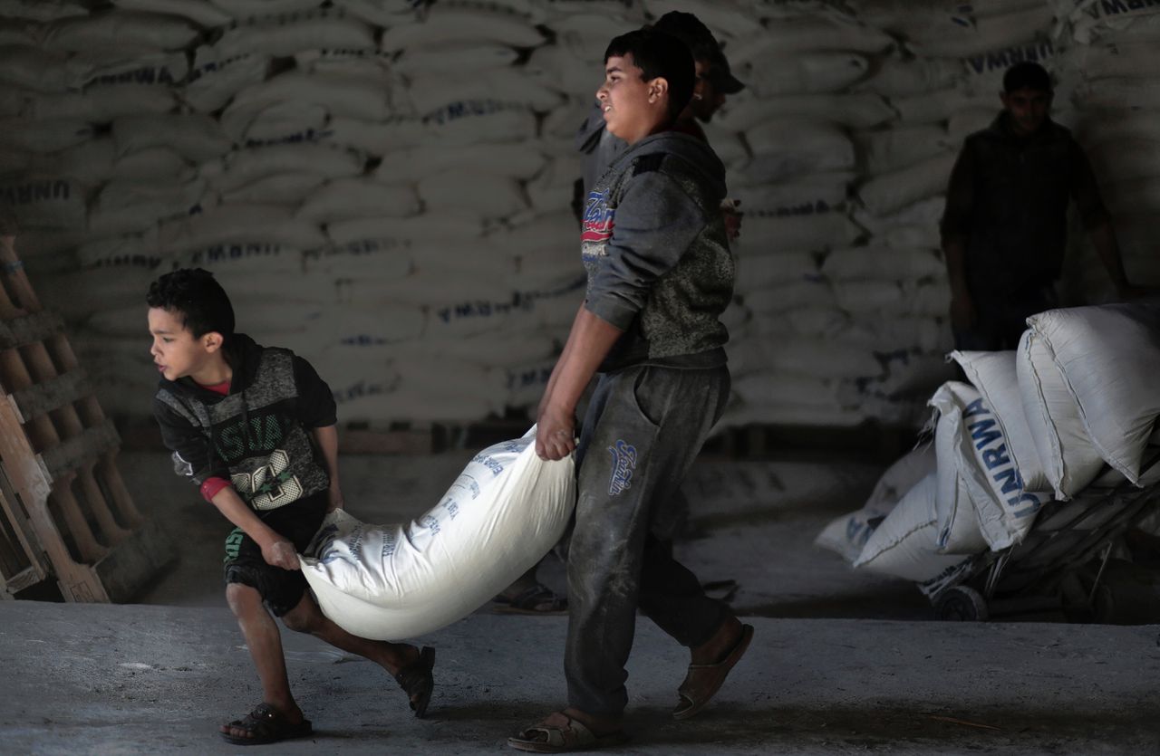 Palestijnen ontvangen voedselhulp in een vluchtelingenkamp.
