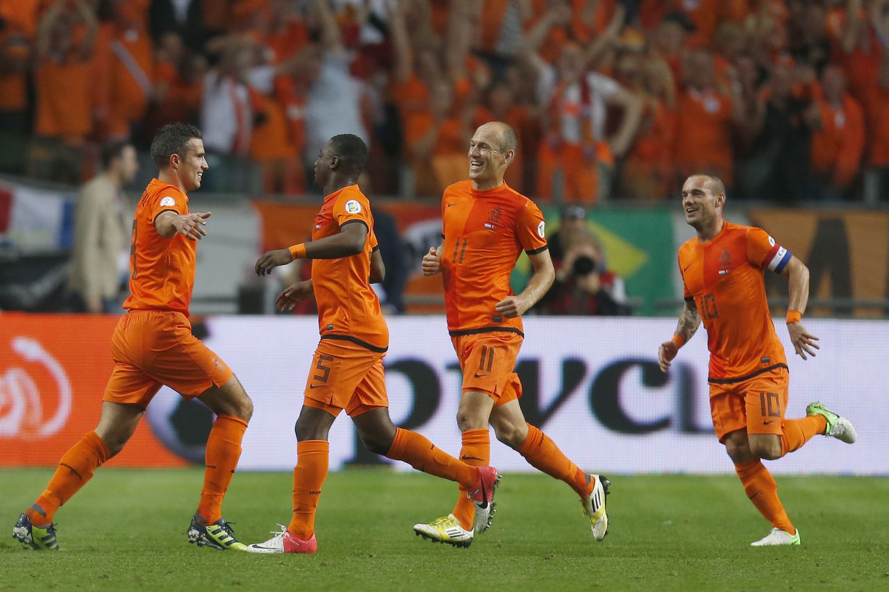 Felicitaties voor Robin van Persie (L) door zijn teamgenoten (VLNR) Jetro Willems, Arjen Robben en Wesley Sneijder na het scoren van 1-0 tijdens Nederland-Turkije in de laatste kwalificatiereeks van Oranje.