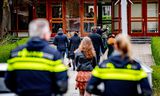 Eerste Paasdag 2021, bij de Mieraskerk in Krimpen aan den IJssel. Kerkgangers arriveren, de politie bewaakt. 