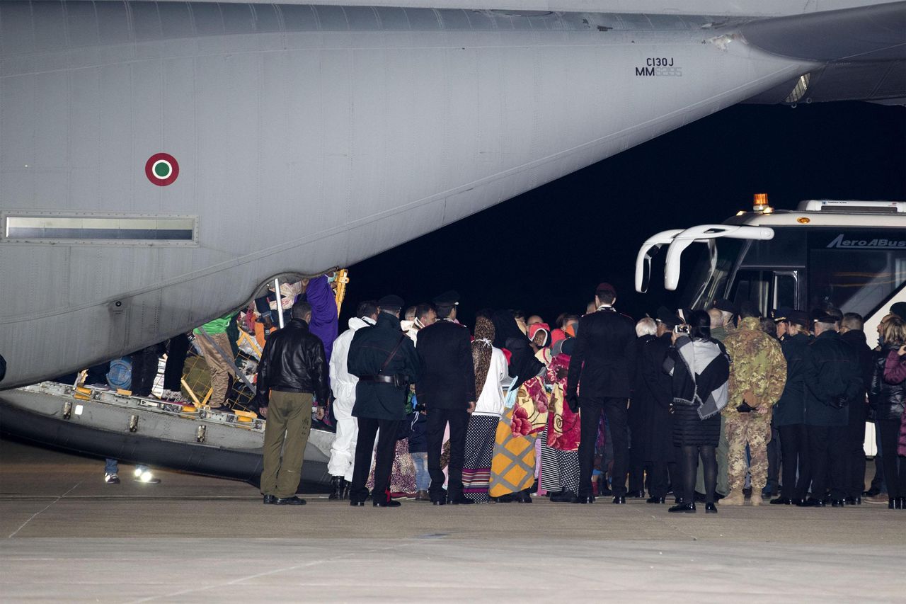Vluchtelingen stappen vrijdag uit een vliegtuig van de Italiaanse luchtmacht op het vliegveld van Pratica di Mare bij Rome.