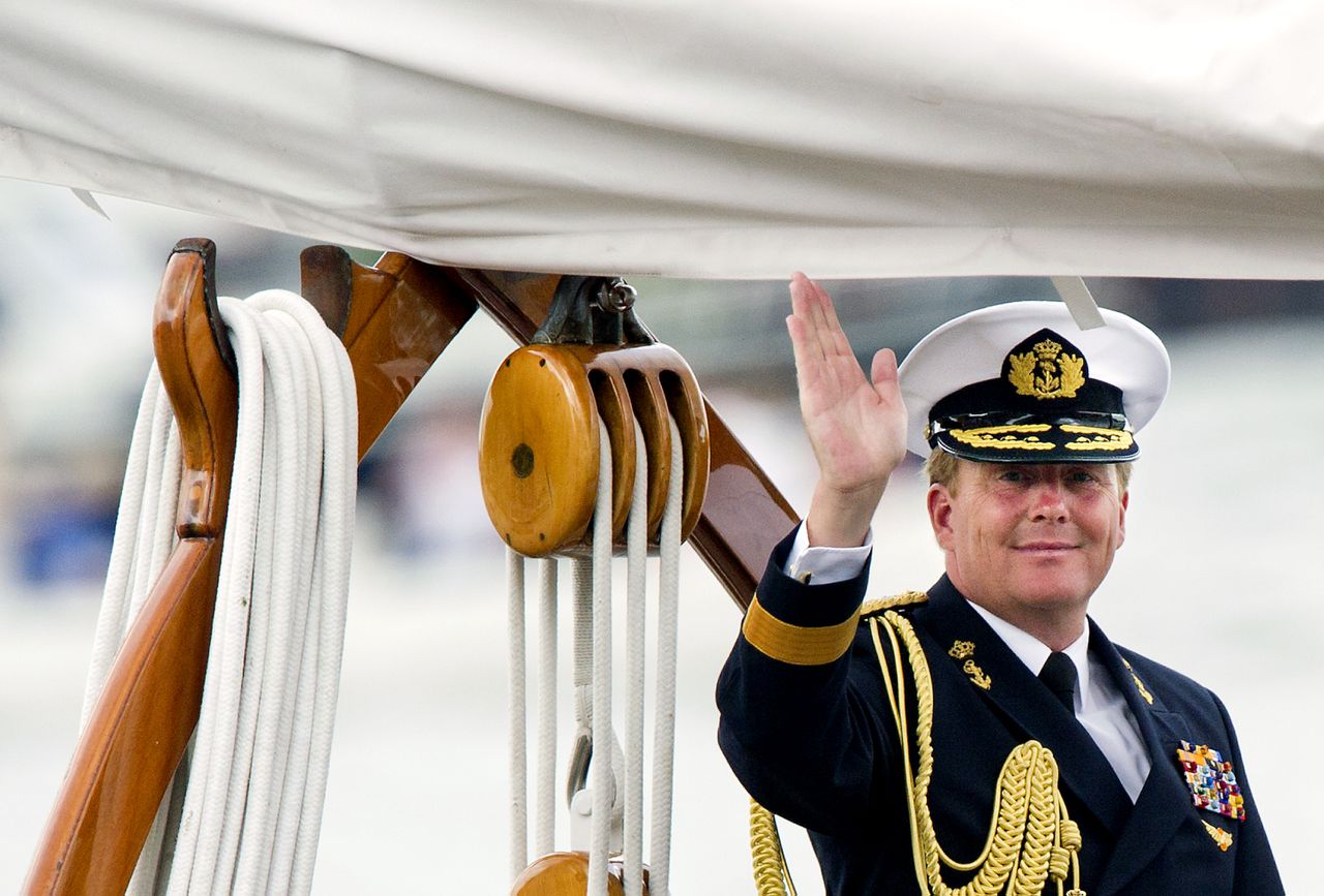 Prins Willem-Alexander zwaait vanaf De Groene Draeck naar passanten op het IJ in Amsterdam voorafgaand aan de traditionele vlootschouw tijdens Sail 2010.