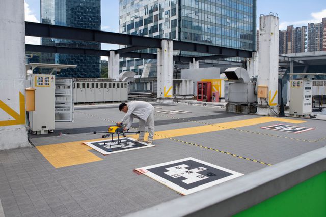 Een medewerker van een dronevliegveldje van bezorgdienst Meituan, in miljoenenstad Shenzhen, controleert een net teruggekeerde drone van een bezorging.