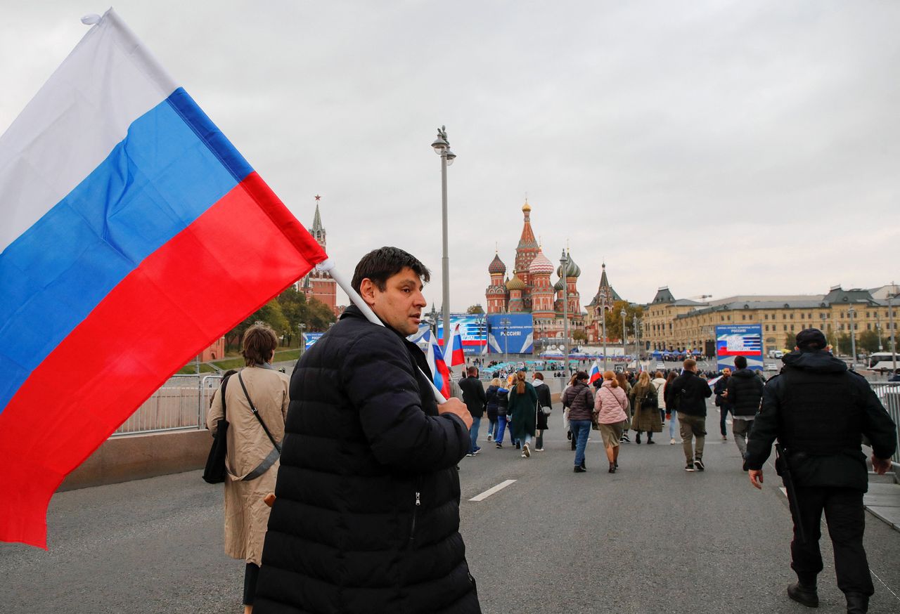 Toeschouwers lopen naar het Rode Plein in Moskou om te kijken naar de toespraak van Poetin.