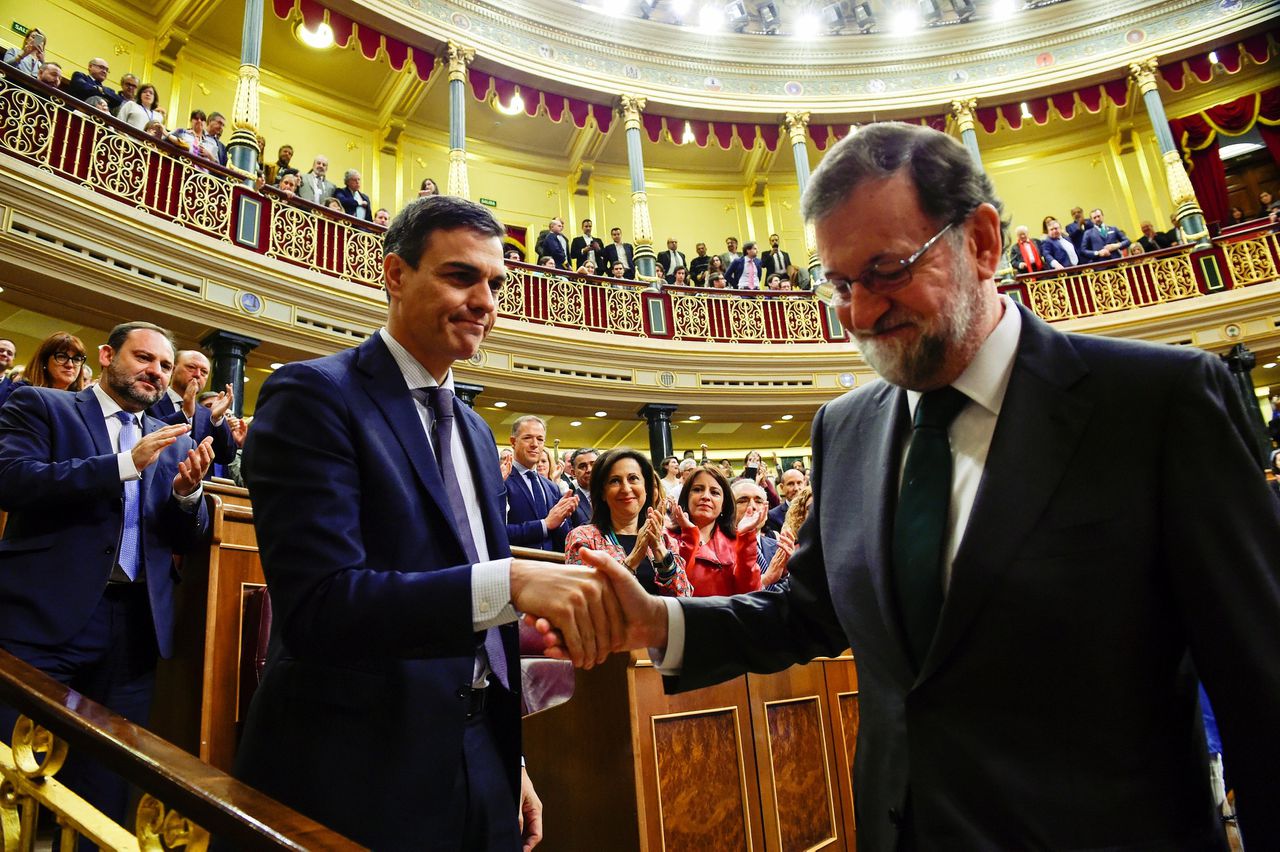 De nieuwe Spaanse premier Pedro Sánchez (links) schudt de hand van vertrekkend premier Mariano Rajoy nadat een motie van wantrouwen tegen hem werd aangenomen.