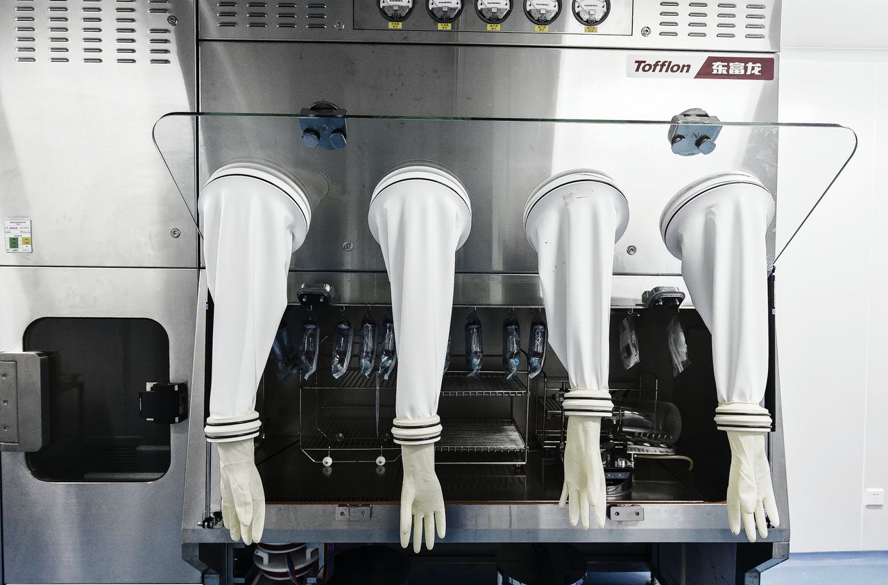Handschoenen voor steriel werk in een isolatiekamer van een farmaceutisch laboratorium in Wuhan in China. Slechts een op de tien ontwikkelde geneesmiddelen haalt de eindstreep