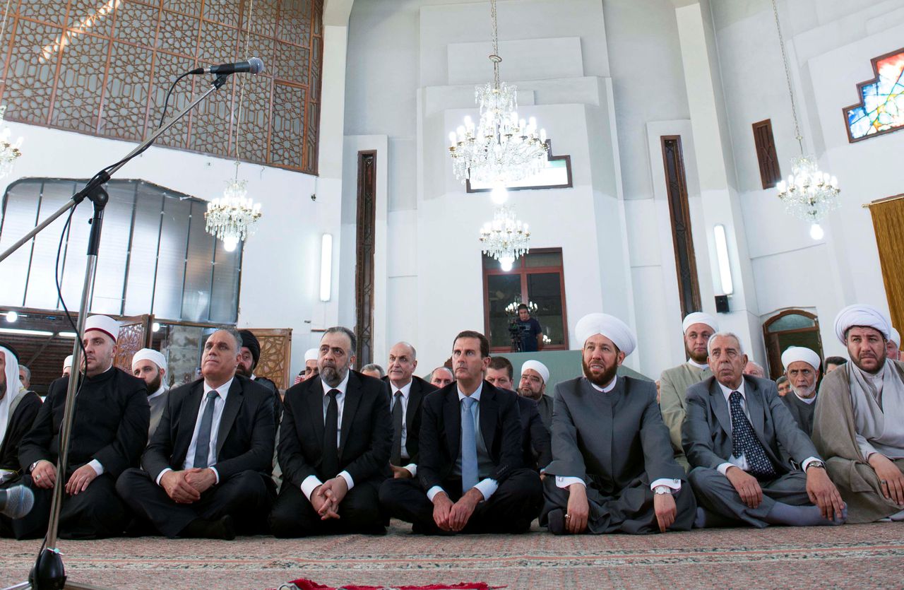 President Bashar al-Assad (midden) woont het gebed in een moskee in Homs bij op de eerste dag van het Suikerfeest.