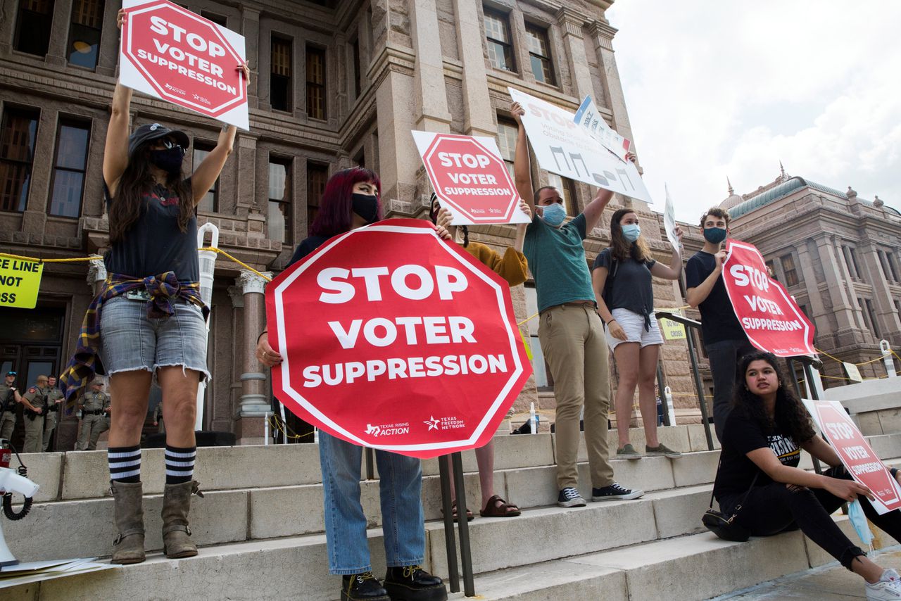 Betogers tegen de nieuwe kieswet voor het parlementsgebouw in de Texaanse hoofdstad Austin. Democraten wisten het Republikeinse voorstel zondag voorlopig te blokkerenr.