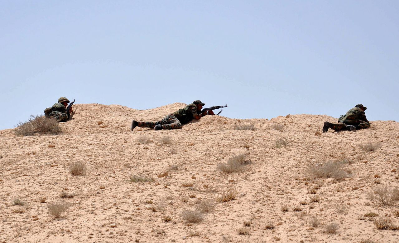 Syrische militairen houden de wacht in de buurt van de stad Palmyra, iets ten oosten van Qaryatain.