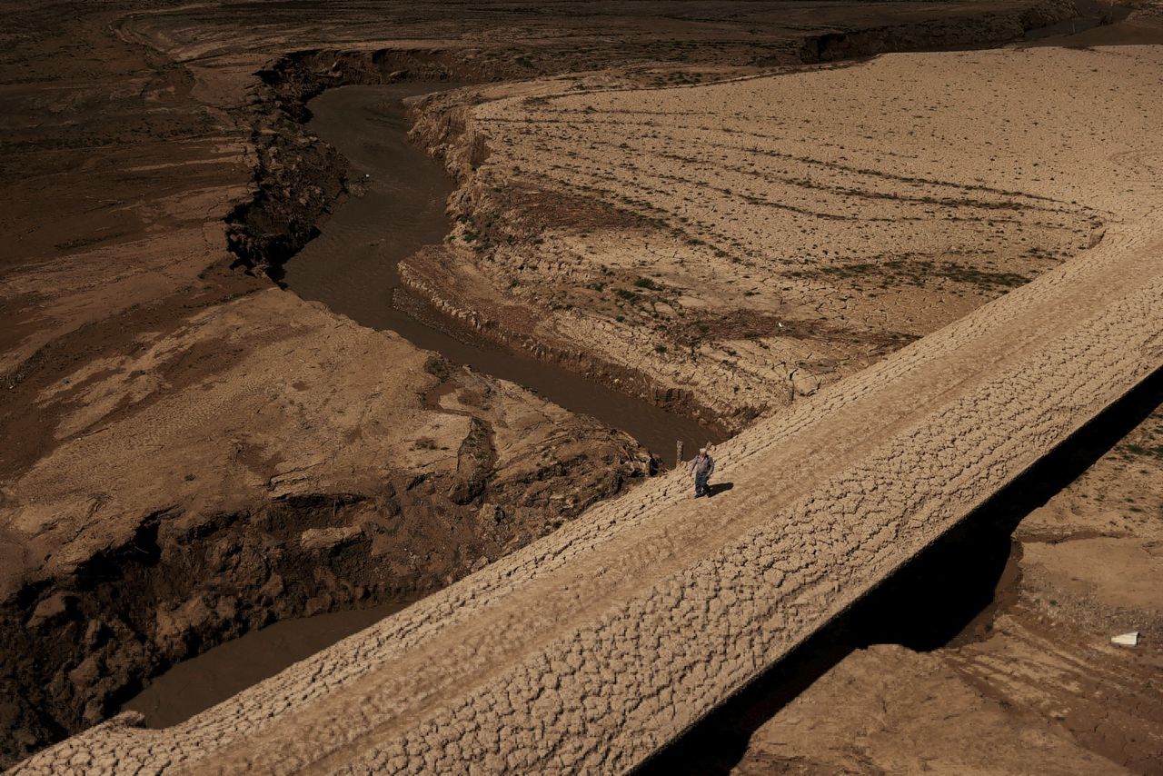 Een man loopt over de door droogte gebarsten grond van een drinkwaterreservoir in het Spaanse Catalonië.