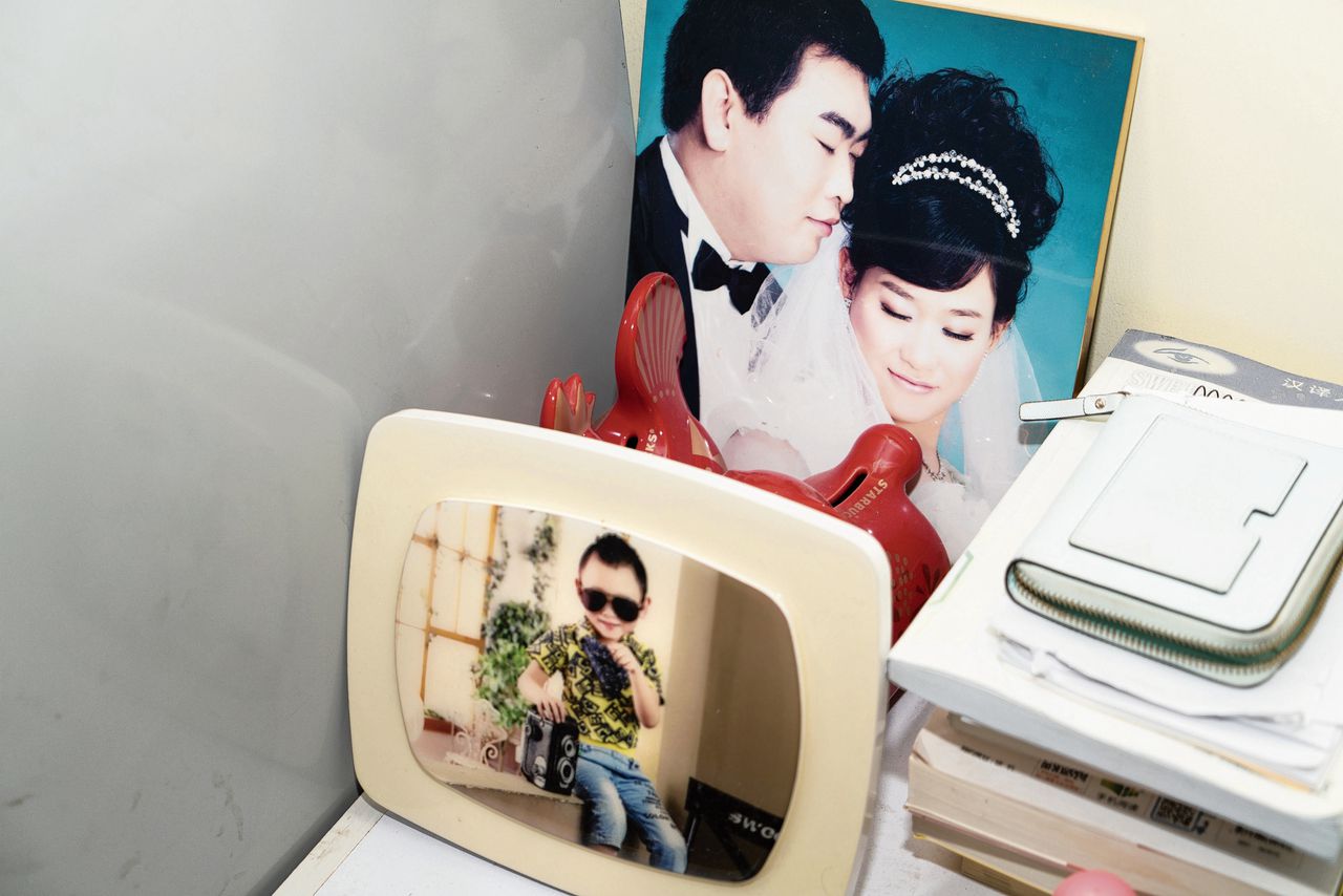 Li Yian (6), te zien op een foto naast de trouwfoto van zijn ouders, is het enige kind van Qi Rui en Li Zhen (beiden 35).