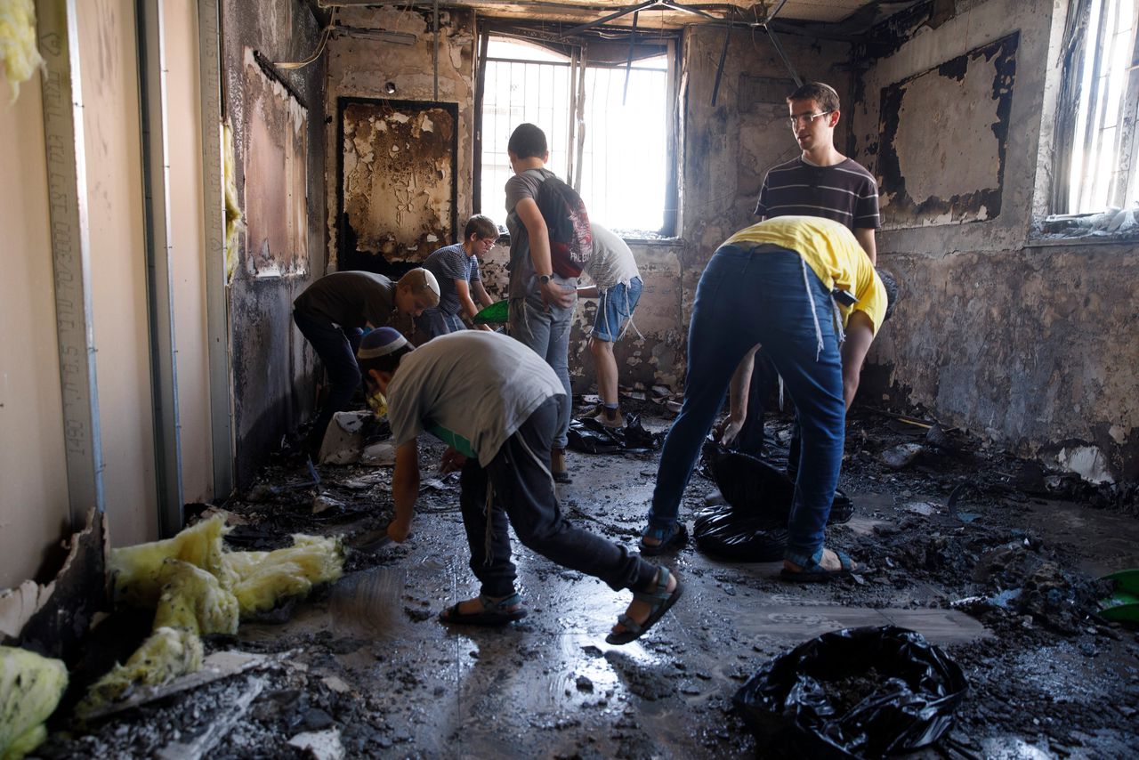 Israëliërs ruimen de ravage op in een religieuze school in Lod, na geweld in de stad op woensdag.