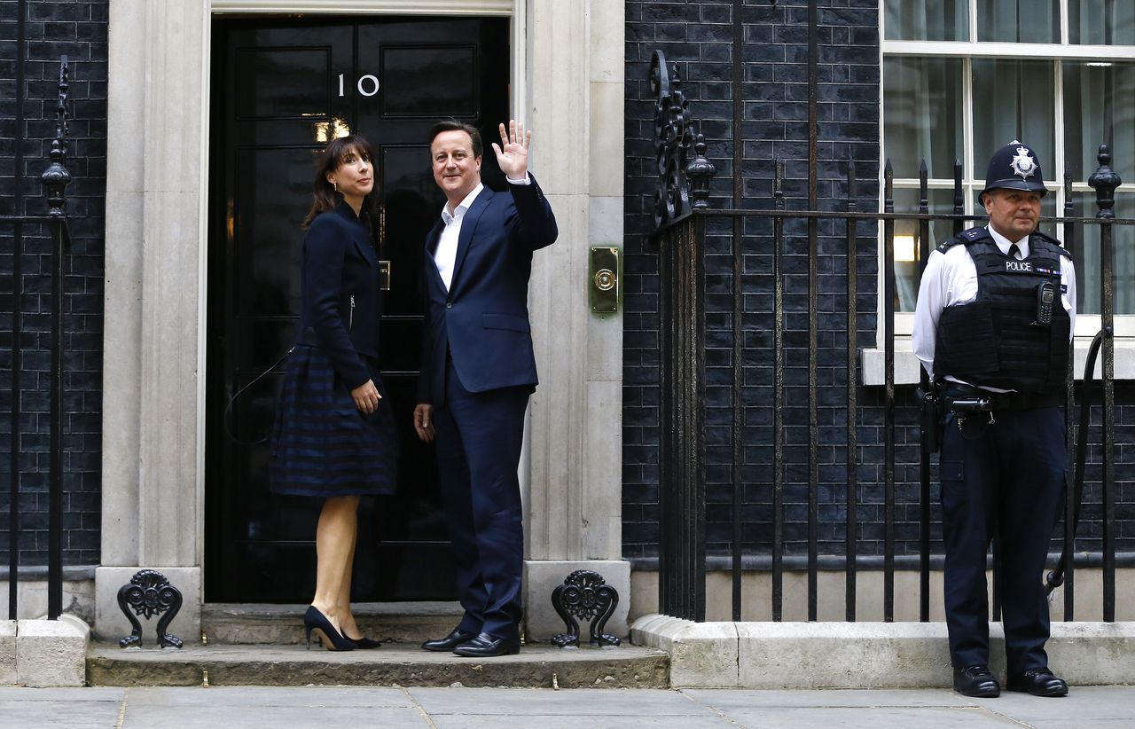 Premier David Cameron en zijn vrouw Samantha keren terug naar 10 Downing Street, de woning van de zittende premier, nadat duidelijk is geworden dat de Conservatieve Partij de Britse Lagerhuisverkiezingen heeft gewonnen.